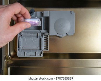 Loading The Soluble-coated Tablets In The Dishwasher. Powder, Dishwashing Detergent And Rinse Aid. Washing Dishes In The Kitchen