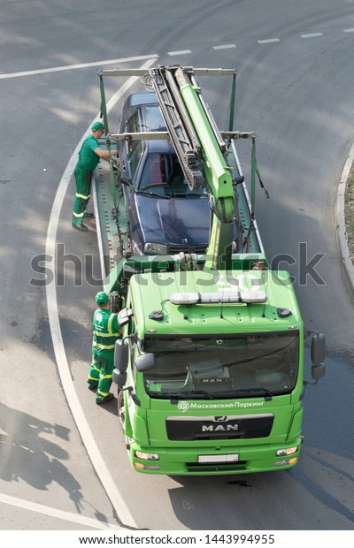Loading and towing a car\
for improper parking. Moscow / Russia - May 2019. Image can be used\
for topics like traffic offense, traffic laws, traffic rules.\
Vertical image