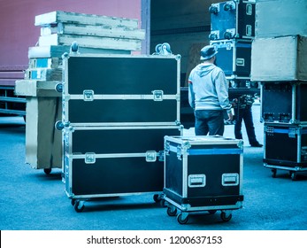 Loading And Unloading Of Concert Equipment. Loading Equipment In A Van. Man Controls The Loading Of Equipment Cases.