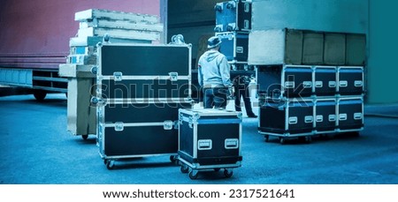 Loading and unloading of concert equipment. Loading equipment in a van. Man controls the loading of equipment cases.