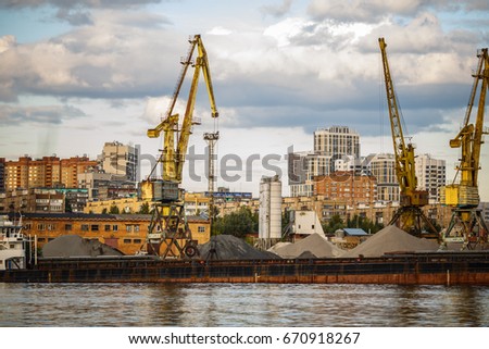 Loading and unloading of sand by crane. The shore of the river Moscow