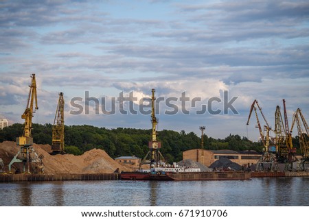 Loading and unloading of sand by crane. The shore of the river Moscow