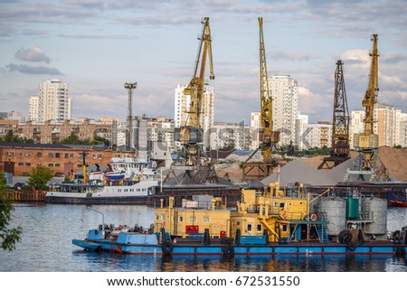 Loading and unloading of sand by crane. The shore of the river Moscow