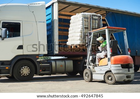 Loading works. Forklift with load and lorry truck