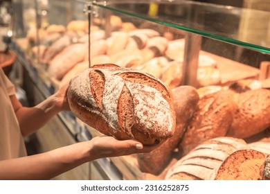 Loaf of bread in female hands in a supermarket. - Powered by Shutterstock