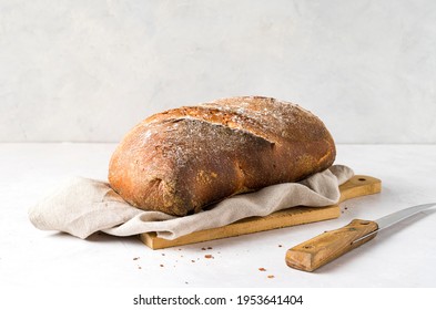 Loaf of bread, and knife, on delicate  background. Front view. Copy space. - Shutterstock ID 1953641404