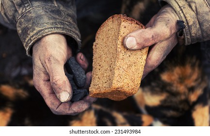 A loaf of bread in an old mans hands