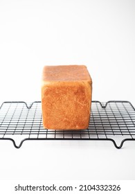 loaf of bread on cooling rack on white background
