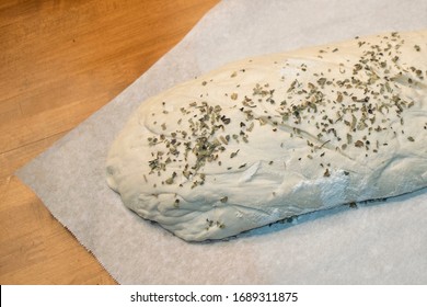 A loaf of crusty white bread that is ready to be put in the overn