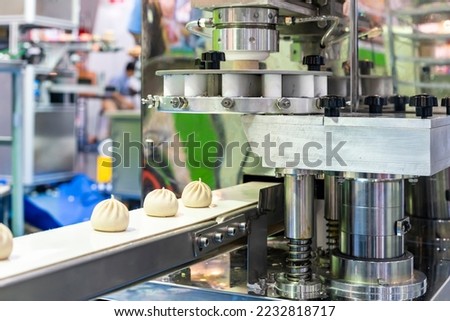 loaf dough chinese or asian food (steamed stuffed buns) on belt conveyor after forming or manufacturing by automatic food making machine in industry