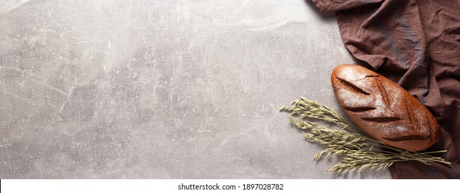 Loaf Of Fresh Bread On Napkin Cloth At Table. Bakery Food At Stone Rustic Background Texture With Copy Space. Flat Lay Of Panorama, Panoramic Top View