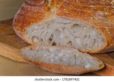 Loaf Of Home Made Craft Bread On Wooden Plate With Sliced Heel.