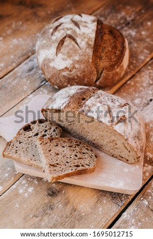 Loaf of a Home made Sourdough bread. Healthy food. Rustic wooden background. 