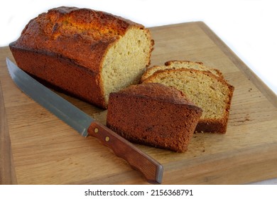 Loaf of Homemade Whole Wheat Banana Bread Loaf on Wood Breadboard with Knife