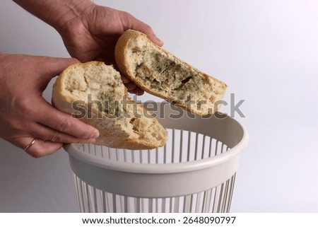 A loaf of moldy bread is thrown into the trash. Disposal of bread.