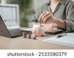 loan, debt, finance, wealth, calculator, fund, tax, growth, profit, retirement. A woman is putting coins into a piggy bank. Concept of saving money and being financially responsible.