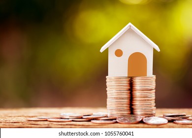 Loan or saving money for buy a house and real estate for family concept, Home model put on the stack coin tower with growing business investment in the in the public park. - Shutterstock ID 1055760041