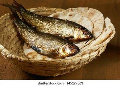 Loaves Of Bread And Two Fishes In A Basket.