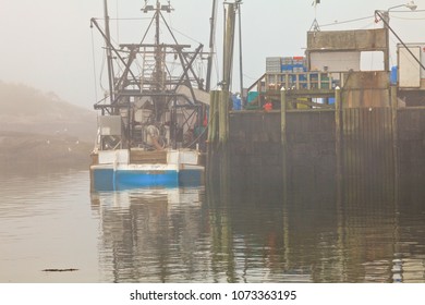 Lobster Boat In The Fog By A Crowded Dock In A New England Fishing Village