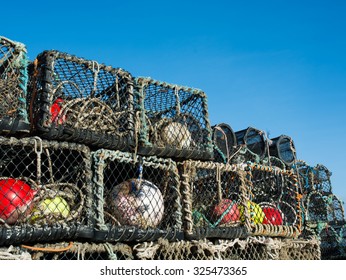 lobster pots stacked on a quayside on a sunny afternoon