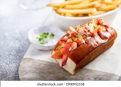 Lobster Roll On A Brioche Bun With Fries On A Marble Board