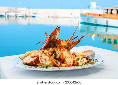 Lobster served with vegetables on white plate. Rethymno, Crete, Greece