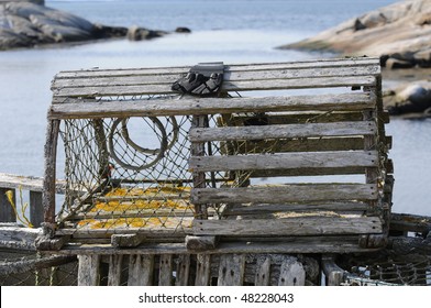 Lobster trap with Peggys Cove harbour in background