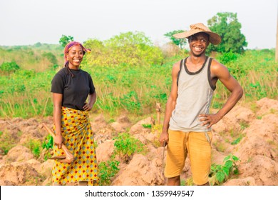 local african farmers on a farm smiling. young african man and woman smiling on a farm