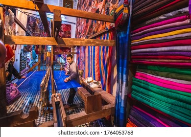 Local artisan weaving  with traditional frame and creating handmade textile in old Medina market. Fes, Morocco - April 10 2016.