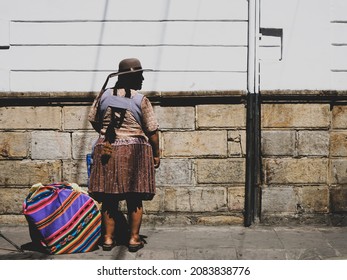 A Local Bolivian Woman Dressed In Traditional Clothes And Waiting Bus At The Center Of Sucre, Bolivia, March 2020. 