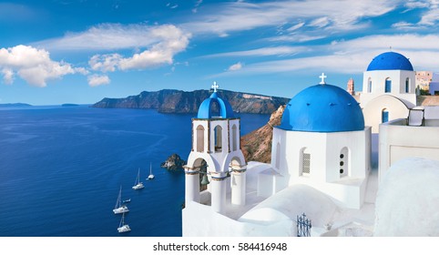Local church with blue cupola in Oia village, Santorini island, Greece, panoramic image