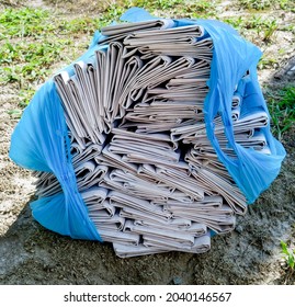 Local Community Newspapers Bundled And Stacked On Street Curb Ready For Neighborhood Delivery.