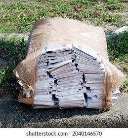 Local Community Newspapers Bundled And Stacked On Street Curb Ready For Neighborhood Delivery.