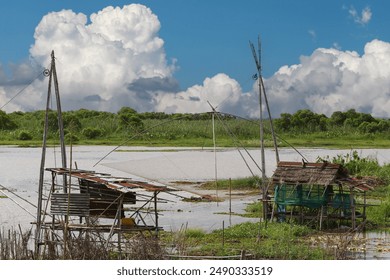 Local fishermen's riverside huts and nets for catching fish, at Nong Han, Udon Thani Province, Thailand. - Powered by Shutterstock