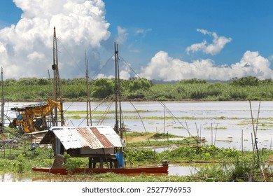 Local fishermen's riverside huts and nets for catching fish, at Nong Han, Udon Thani Province, Thailand. - Powered by Shutterstock