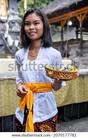 Local Girl in a Balinese temple carrying offerings, Kintamani, Bali 