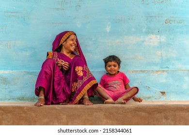 Local indian woman and child in front of her  colorful  house. Ranchha India on May 11 2022.  Indian Mother with child.                                 