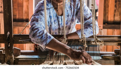 The local Intha woman weaving the lotus cloth with the hand loom at the local lotus cloth weaving factory in Inle lake, Shan State, Myanmar. Selective focused