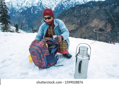 Local Kashmiri Old Woman Serving Hot Tea And Coffee With Beautiful Snow Mountain Landscapes In The Background, Tourist Season, Kashmir Travel Holiday Destination,India.