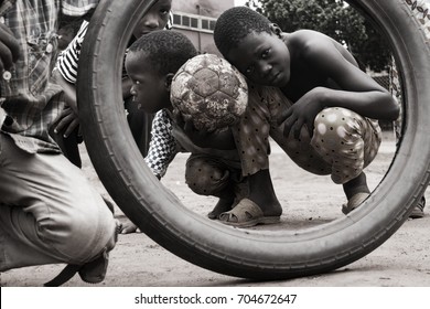 local kids on a street pose for my picture with ball and tire - Powered by Shutterstock