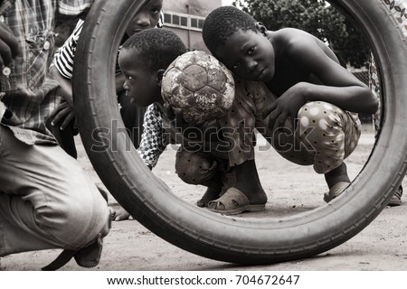 local kids on a street pose for my picture with ball and tire