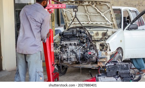 A Local Mechanic Doing An Engine Swap On A Small Car And Putting In New Engine. Complete Engine Overhaul With New Gear Alterations Are Being Done