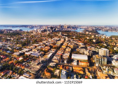 Local Residential Suburbs In Inner City Of Sydney On Shores Of Sydney Harbour Viewed From Above Mid-air On A Sunny Day Facing CBD Landmarks.