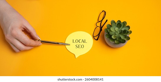 Local SEO, Search Engine Optimization. Process of optimizing a website or online presence to improve its visibility in local search results. A woman's hand points to notes