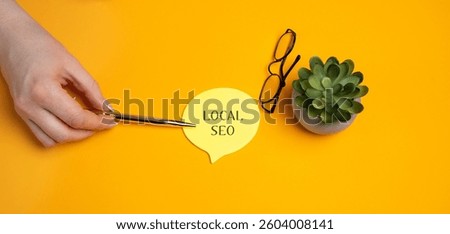 Local SEO, Search Engine Optimization. Process of optimizing a website or online presence to improve its visibility in local search results. A woman's hand points to notes