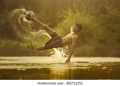 Local Soccer player with ball in action outdoors.Splashing water.