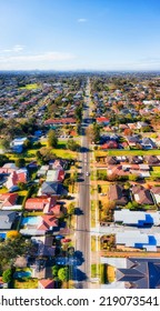 Local Traffic Residential Street In City Of Ryde - Vertical Aerial Panorama Towards Distant Sydney City CBD Skyline.