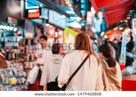 local travel activity concept from asian woman shopping and eat street food at night of south korea market
