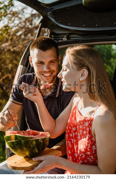 Local travel, Romantic\
Picnic Date Ideas. couple in love on summer picnic with watermelon\
in car trunk