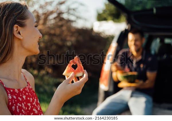 Local travel, Romantic\
Picnic Date Ideas. couple in love on summer picnic with watermelon\
in car trunk